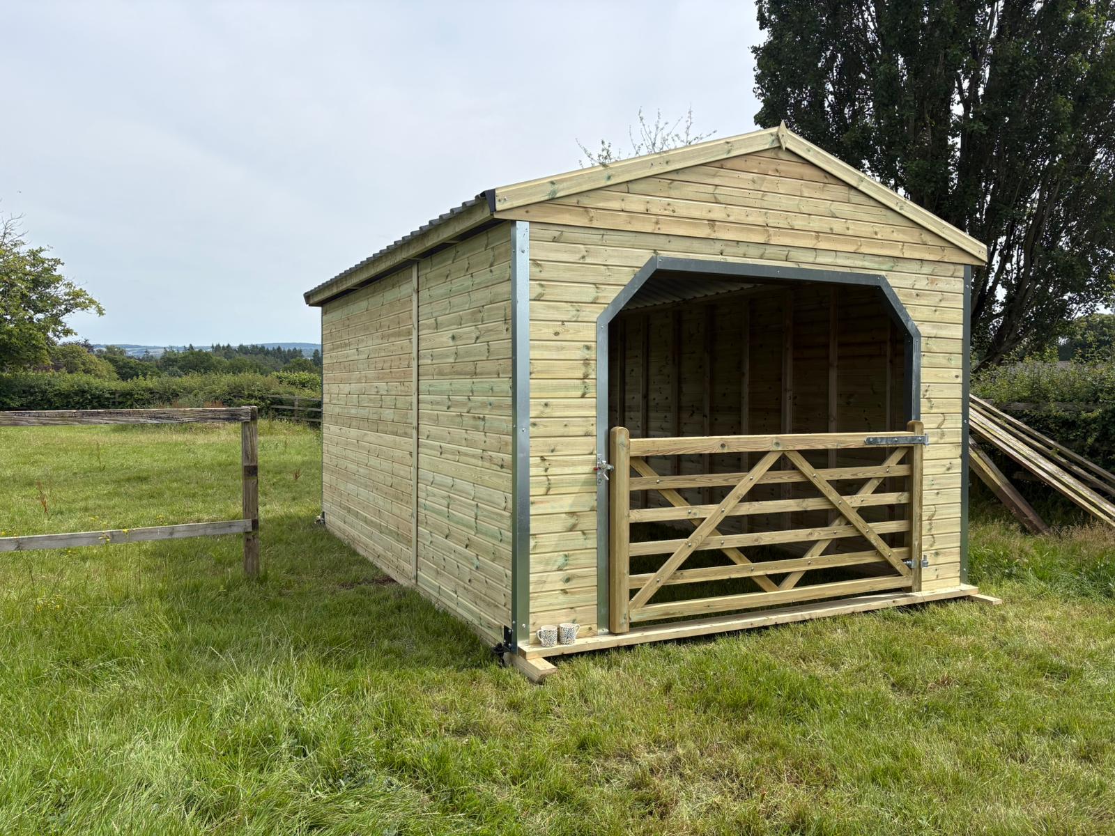Hunter Stables 12ft x 18ft walk through field shelter with timber gates, pressure-treated timber construction, and open access design for horses and livestock.