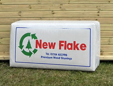 Mendip New Flake Large Flake Wood Shavings leaning against a timber stable building