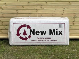 Mendip New Mix Wood Shavings leaning against a timber stable building