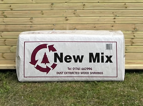 Mendip New Mix Wood Shavings leaning against a timber stable building