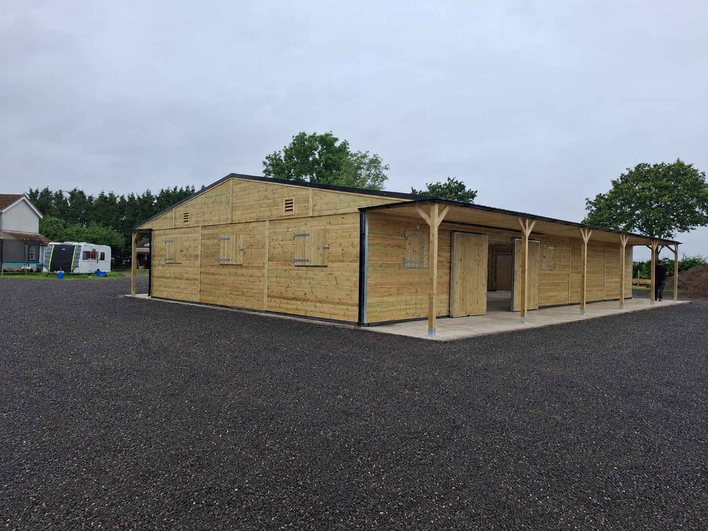 Large timber American barn featuring open entrances and 6ft roof overhangs