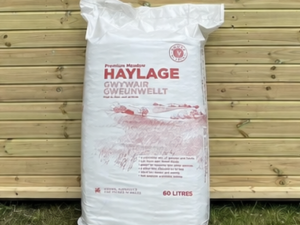 Gower Granary Haylage 60L bag leaning against a timber stable building