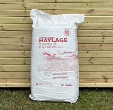 Gower Granary Haylage 60L bag leaning against a timber stable building
