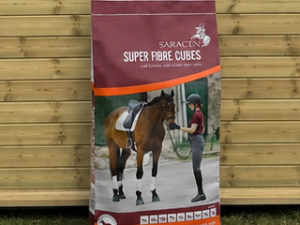 Saracen Super Fibre Cubes 20kg bag leaning against a timber stable building