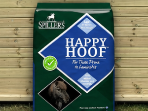 Spillers Happy Hoof 20kg leaning against a timber stable building