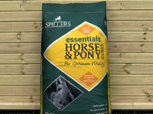 Spillers Horse and Pony Cubes 20kg bag leaning against a timber stable building