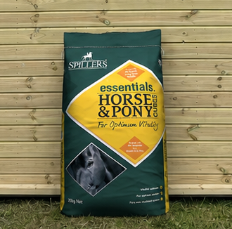 Spillers Horse and Pony Cubes 20kg bag leaning against a timber stable building