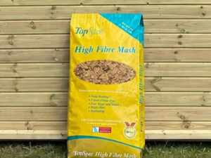 Top Spec High Fibre Mas hleaning against a timber stable building