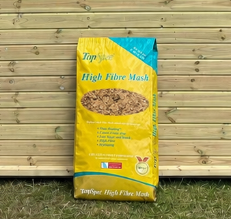 Top Spec High Fibre Mas hleaning against a timber stable building