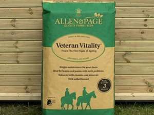 Allen and Page Veteran Vitality bag leaning against a timber stable building