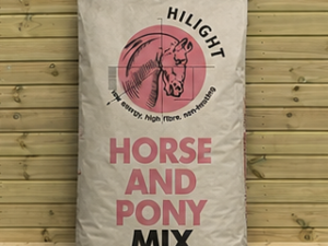 HiLight Horse and Pony Mix feed leaning against a timber stable building