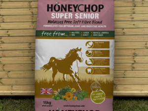 Honeychop Super Senior feed leaning against a timber stable building
