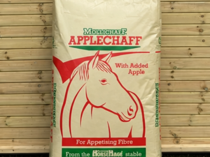 Mollichaff Applechaff feed leaning against a timber stable building