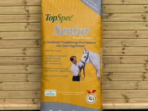 TopSpec Senior Balancer feed leaning against a timber stable building